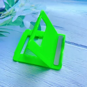 Close-up detail of the foldable and adjustable green neon plastic phone holder stand