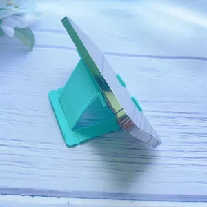 Side view of foldable teal phone stand supporting a smartphone on a wooden surface