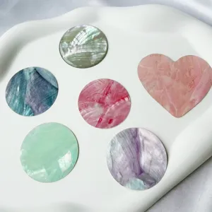 Vue macro d'autocollants en nacre naturelle irisée, en formes rondes et de cœurs pour le DIY