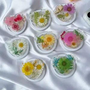 Primer plano de soportes de resina para móvil en forma de corazón con flores secas reales
