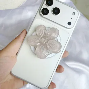 Nahaufnahme des schimmernden Handy-Griffs aus Kunstharz in Blumenform auf einem Smartphone