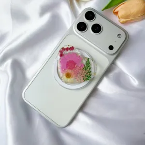 Detalle de soporte para móvil de resina en forma de corazón con flores secas reales