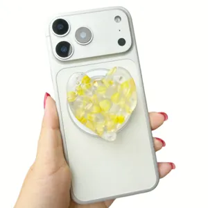 Close-up detail of a 3D heart-shaped phone grip with embedded yellow real flower petals