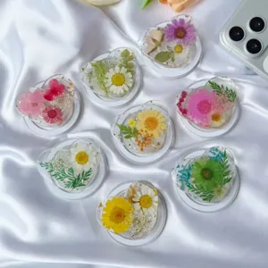 Detalle de varios soportes para móvil en forma de corazón con resina de flores secas