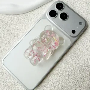 Dettaglio supporto cellulare orsetto 3D trasparente con petali rosa su telefono bianco