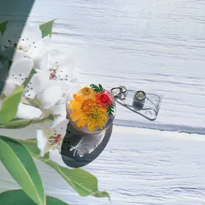 Close-up detail of a handmade resin badge reel with colorful real dried flowers.