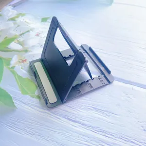 Close-up of a black foldable desktop phone stand showing adjustable angle slots