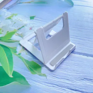 Close-up detail of white foldable plastic desktop stand for smartphones and tablets