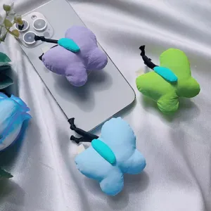 Primer plano de tres soportes de tela para móvil con forma de mariposa en lila, verde y azul.