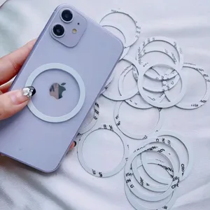 Close-up view of a universal white Magsafe magnetic ring attached to a purple smartphone