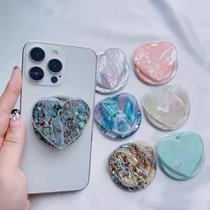 Detailed view of heart-shaped phone grips with iridescent natural shell textures