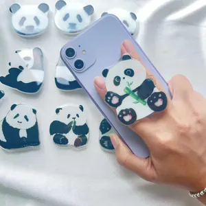 Close-up of cute acrylic panda phone grip stand attached to a purple smartphone