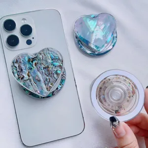 Detail view of heart-shaped iridescent MagSafe phone grip with natural shell texture