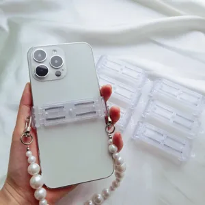 Nahaufnahme eines transparenten Handy-Clips mit elegantem Perlenband auf Stoff