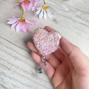 Nahaufnahme eines herzförmigen rosa Glitzer-Ausweishalters für Krankenschwestern.