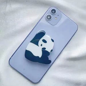 Close-up view of a cute panda acrylic phone grip holder attached to a purple smartphone