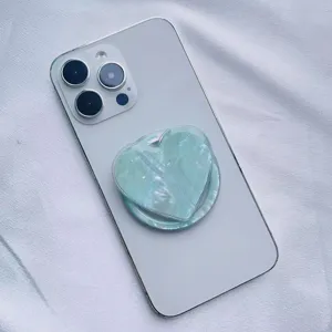 Detailed view of iridescent heart-shaped seashell pattern MagSafe phone grip accessory.