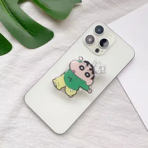 Nahaufnahme der Crayon Shin-chan Handyhalterung aus Acryl an einem weißen Smartphone