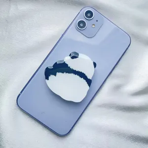 Cute minimalist panda acrylic phone socket grip stand attached to a purple smartphone