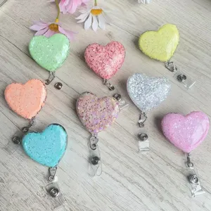 Bunte glitzernde Herz-Ausweishalter für Krankenschwestern und Ärzte auf Holzgrund.