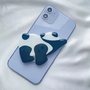 Macro view of a cute acrylic panda phone socket grip attached to a purple smartphone