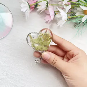 Nahaufnahme eines herzförmigen Ausweis-Jojo mit echten getrockneten Blumen