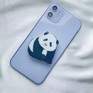 Detailed close-up showing a cute panda acrylic phone grip attached to a purple smartphone