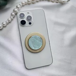 Dettaglio macro dell'elegante supporto magnetico per telefono con motivo a conchiglia.