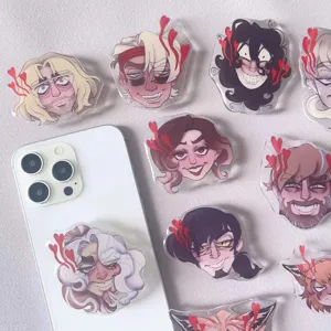 Close-up of cartoon anime acrylic phone grips with character faces and heart details