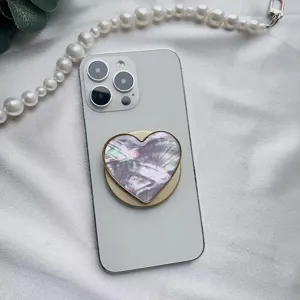 Dettaglio macro del supporto per telefono a forma di cuore con trama in madreperla