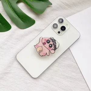 Detailansicht eines Shin-chan-Anime-Acryl-Handygriffständers auf einem weißen Smartphone