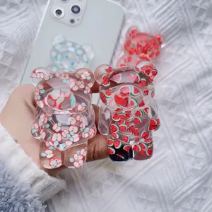 Detailed view of transparent cute bear phone grips with apple and watermelon patterns