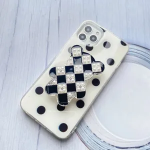 Vista dettagliata del supporto per telefono a forma di orso a scacchi con perle e pois