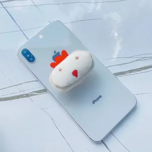 Vue détaillée de près d'un support de téléphone en peluche blanche en forme de petit poulet