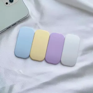 Quattro supporti per telefono a molla in colori macaron su tessuto bianco con trama fine