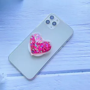 Detaillierte Nahaufnahme eines rosa glitzernden Herz-Quicksand-Handygriffs am Smartphone