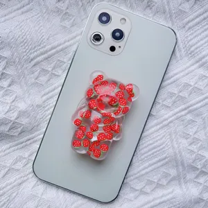 Cute 3D resin bear phone grip accessory with strawberry pattern on light green phone