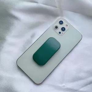 Supporto per cellulare ovale verde scuro opaco sul retro di uno smartphone bianco