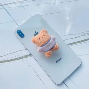 Support de téléphone pliable en peluche ours pêche mignon sur un smartphone blanc