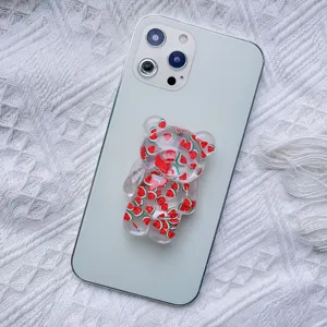 Close-up of cute bear-shaped transparent phone grip with watermelon pattern on phone
