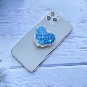 Nahaufnahme eines herzförmigen Telefonsockels mit funkelndem blauem Treibsand-Glitzer