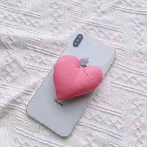 Detaillierte Nahaufnahme einer weichen rosa herzförmigen Stoff-Handyhalterung auf einem Handy