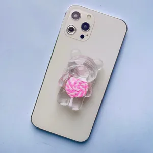Dettaglio del supporto per telefono orso trasparente con design lecca-lecca rosa