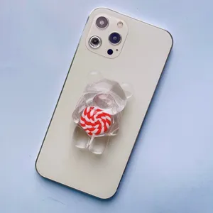 Primo piano di un supporto per telefono a forma di orso con lecca-lecca rosso