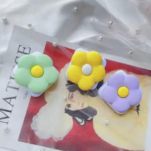 Close-up van kleurrijke bloemvormige telefoonhouders met spiegels op een kanten achtergrond