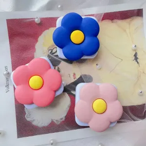 Detailweergave van schattige bloemvormige vouwbare telefoonhouders en spiegels op achtergrond