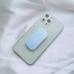 Primo piano di un supporto per telefono color azzurro macaron su uno smartphone verde.