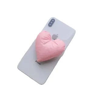 Minimalistische rosa Herz-Handyhalterung aus Stoff als Zubehör auf einem weißen Smartphone