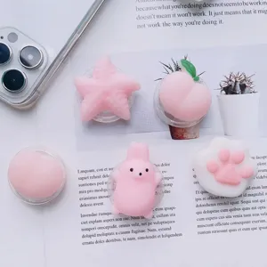 Close-up of cute pink 3D cartoon squishy phone grip stands in starfish and peach shapes
