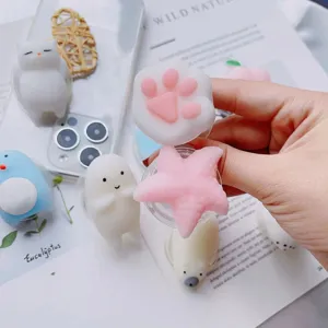 Close-up of cute squishy silicone phone grips in cat paw and star shapes held by hand.